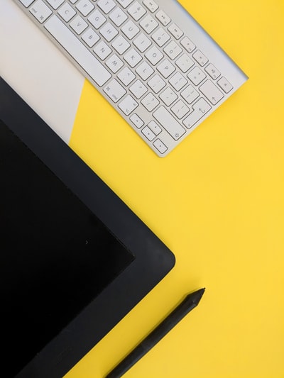 灰色苹果无线键盘旁边的黑色平板电脑和手写笔